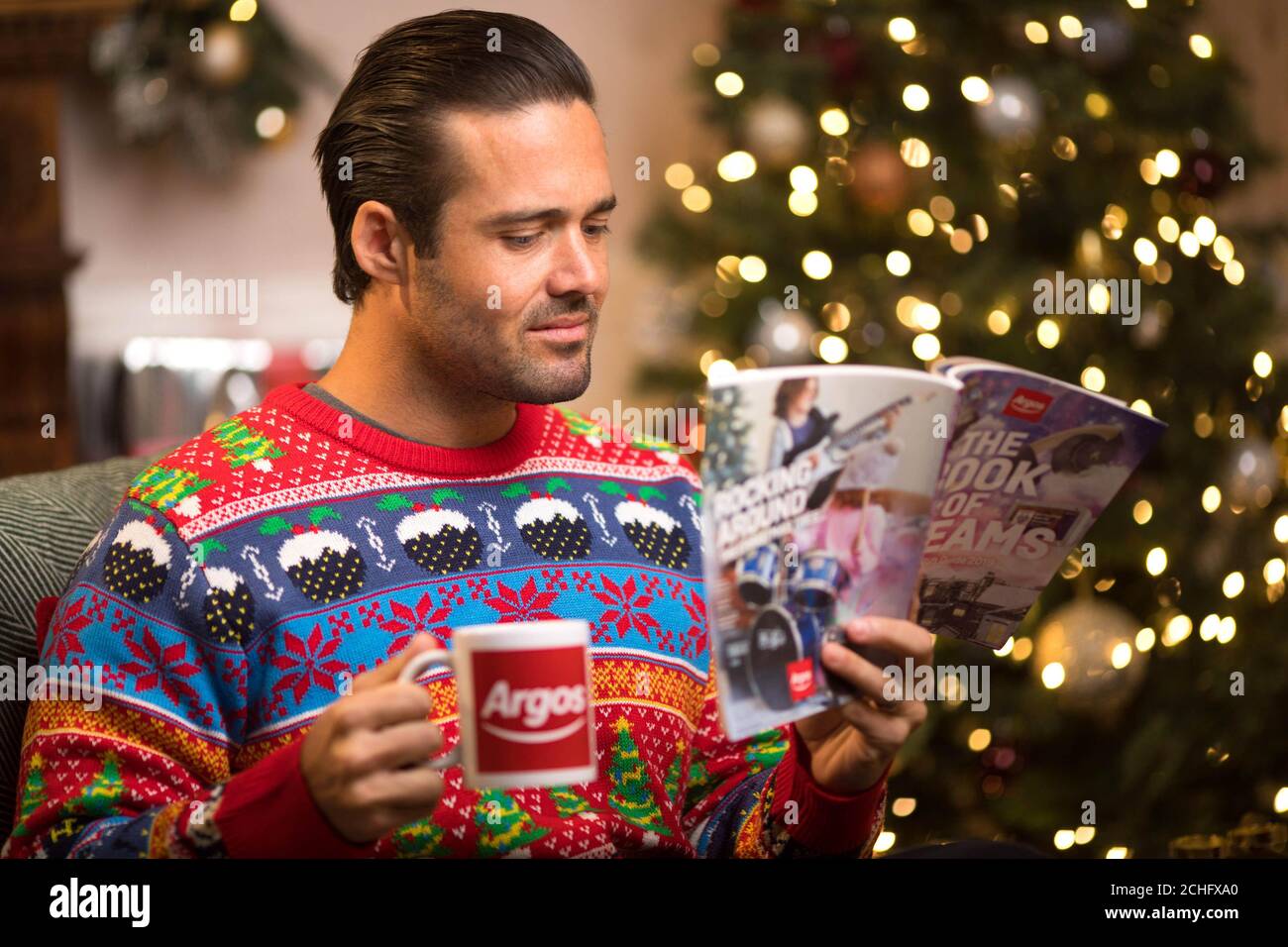 Spencer Matthews reads to children to launch the Argos Christmas Story Time event which will take place in its London Tottenham Court Road store on Sunday 8th December. PA Photo. Issue date: Thursday December 5, 2019. The event celebrates the festive tradition of circling gifts in the Argos catalogue and aims to encourage parents to spend time reading with their children. Customers are being encouraged to wear a Christmas jumper to the event and can book a slot by visiting the Argos Christmas Story Time Eventbrite page. A limited number of walk-in spaces will also be availab Stock Photo