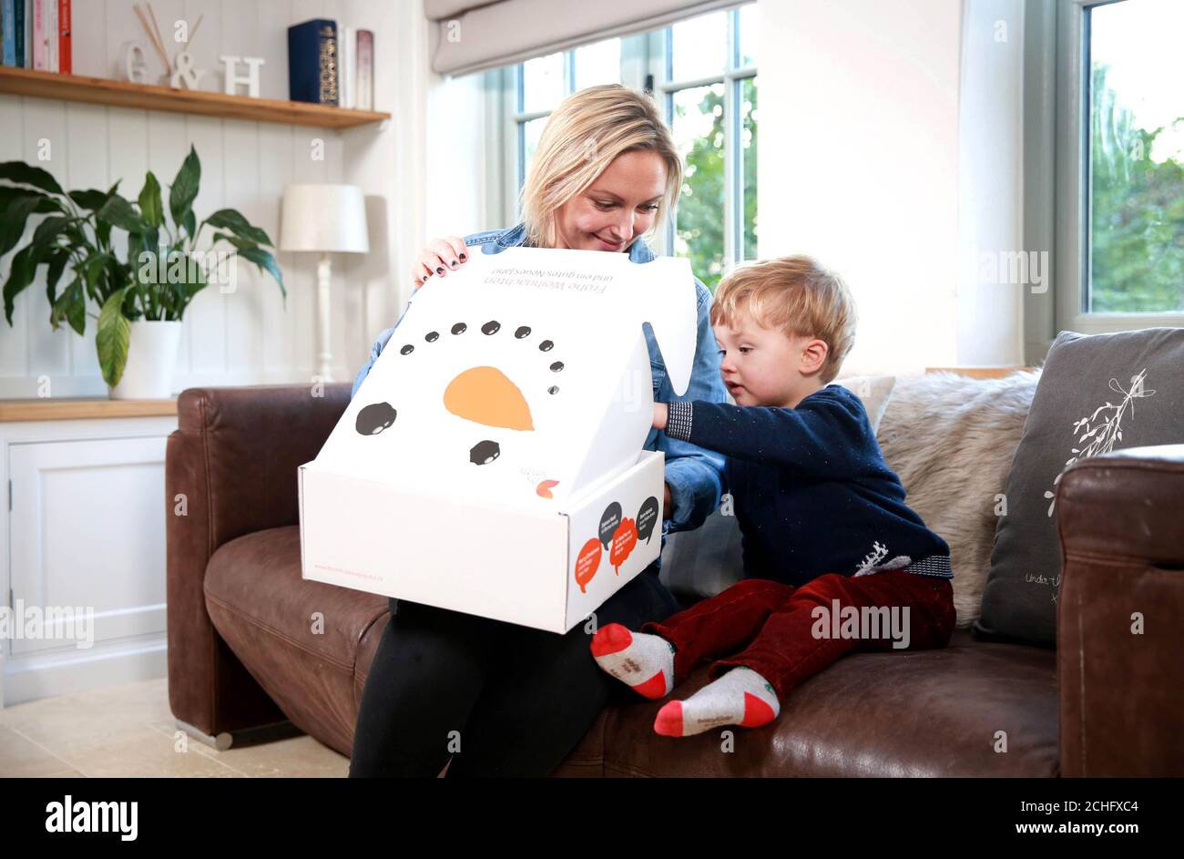 EDITORIAL USE ONLY Hayley Dawson and her son Jack, age 2, unbox their Christmas purchases ready to gift to family and friends, as FTSE 100 packaging company DS Smith reports its half-year results today, revealing a record run-up to this year???s festive season with e-commerce orders on sustainable cardboard and paper boxes up by almost half on last year. Stock Photo
