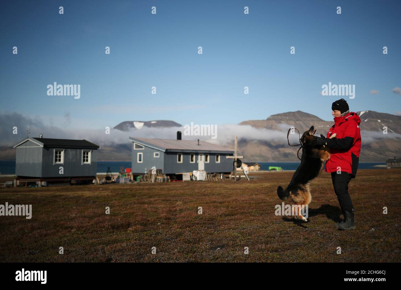 Christiane Huebner plays with her dog Svea in front of her home in the town  of Longyearbyen, in Svalbard, Norway, August 3, 2019. Three years ago, as  winter approached, 13 meters of