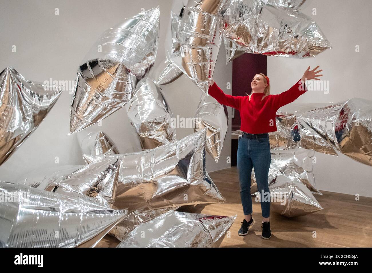 A Tate Modern gallery assistant interacts with the 'Silver Clouds' installation, at a press view of major new Andy Warhol exhibition at Tate Modern, London, which features classic pop art pieces and works never shown before in the UK. PA Photo. Picture date: Tuesday March 10, 2020. Photo credit should read: Dominic Lipinski/PA Wire Stock Photo