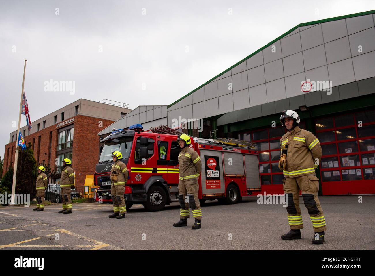 Firefighters observe a minute's silence outside Bournbrook Community fire station in Birmingham, in memory of their colleagues that lost their lives in the line of duty. Stock Photo