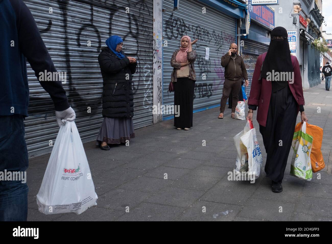 Members of the Islamic community in Bethnal Green, east London go about their daily business during the holy month of Ramadan as the UK continues in lockdown to help curb the spread of the coronavirus. Stock Photo