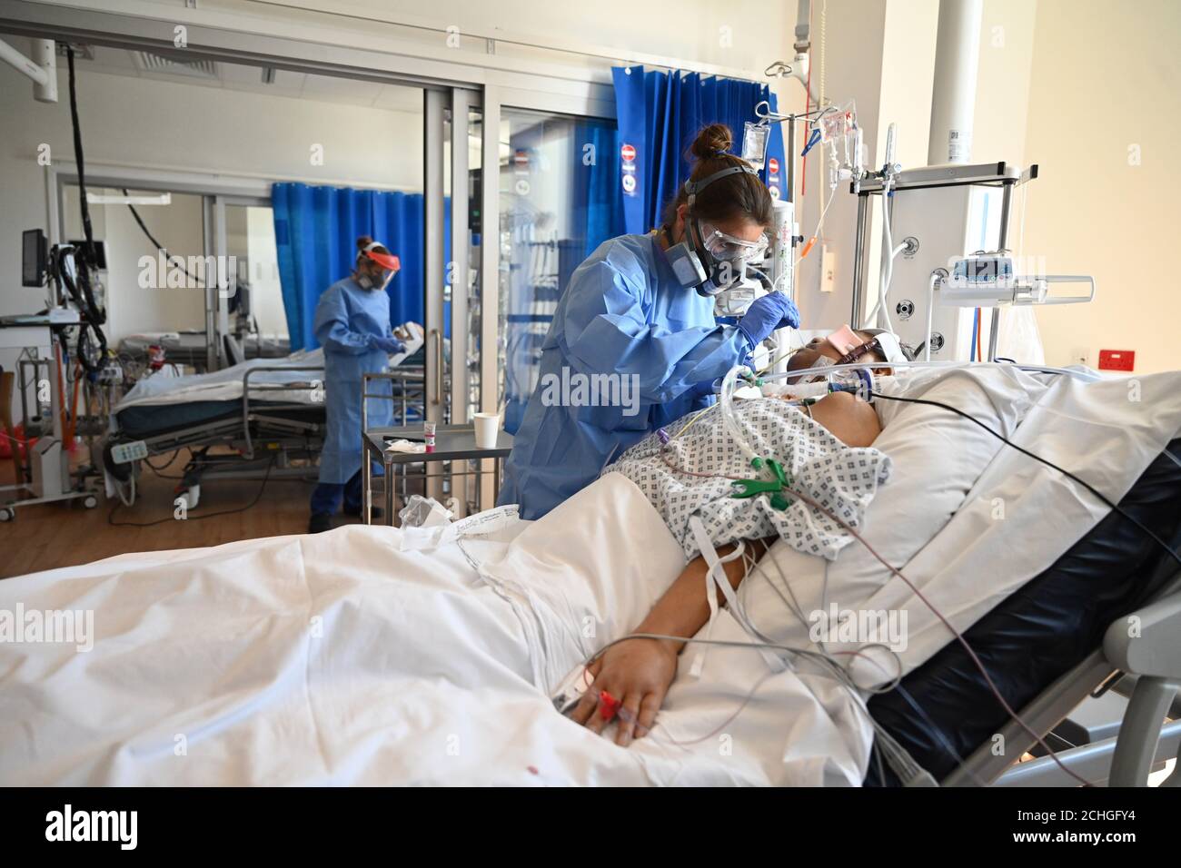 Clinical staff wear Personal Protective Equipment (PPE) as they care for a patient at the Intensive Care Unit at the Royal Papworth Hospital in Cambridge. Stock Photo