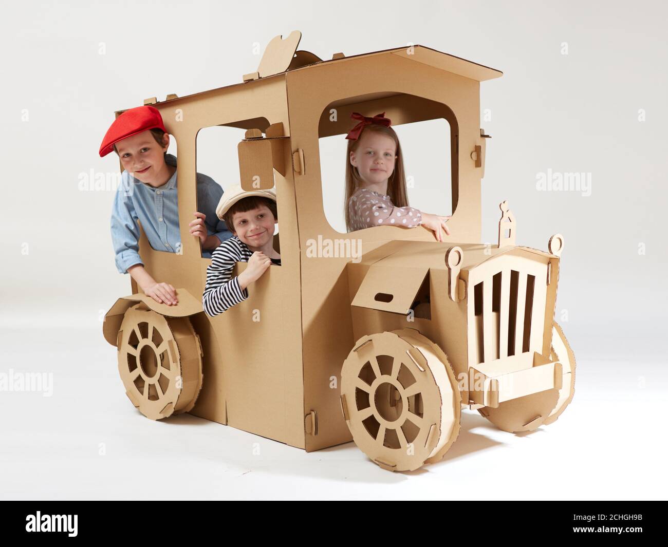 Creative children plays in cardboard car playhouse Stock Photo - Alamy