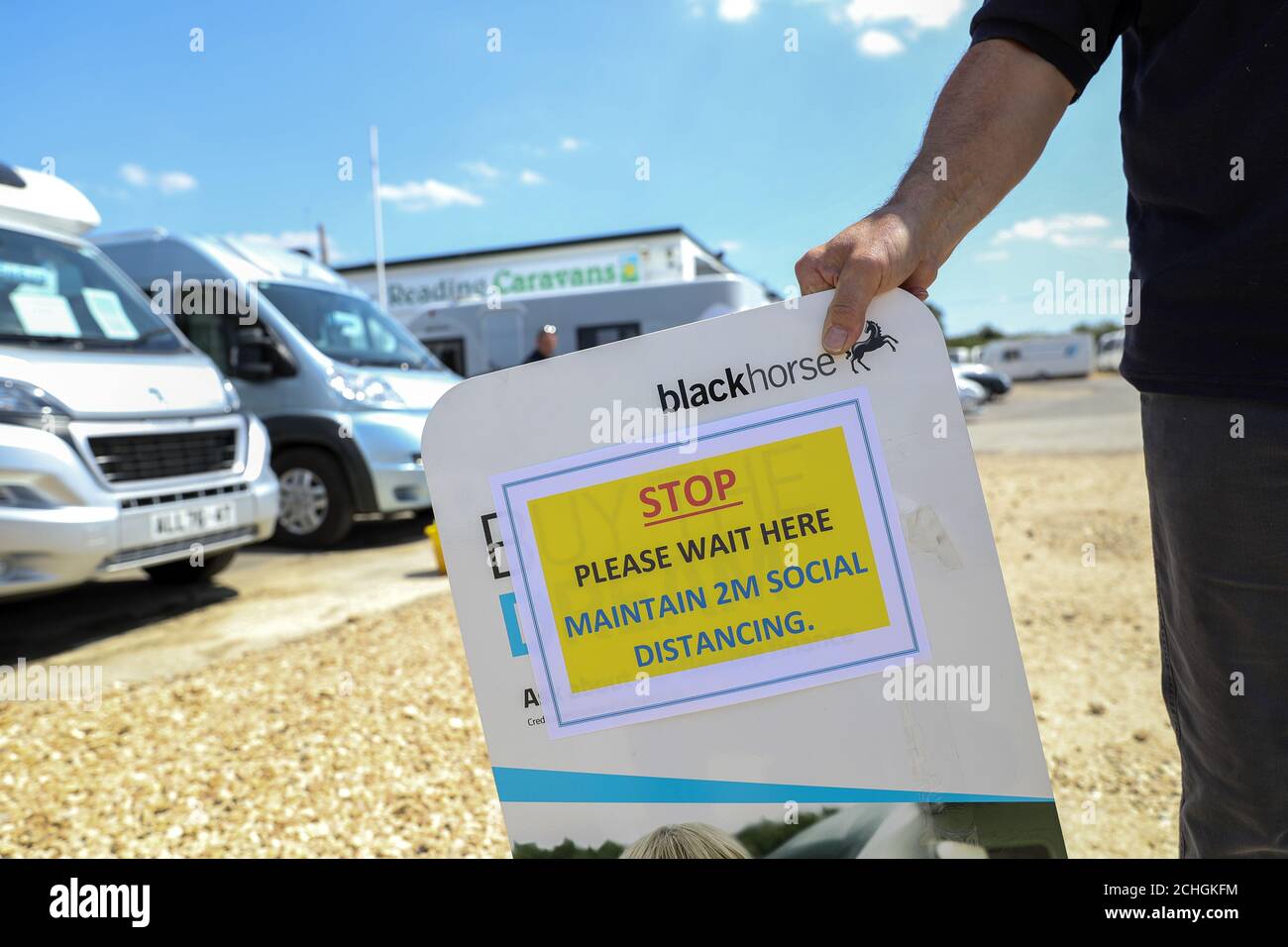 Ian Stamp puts up social distancing signs at Reading Caravan and Motorhome Centre following the introduction of measures to ease England out of lockdown. PA Photo. Picture date: Monday June 1, 2020. See PA story HEALTH Coronavirus. Photo credit should read: Steve Parsons/PA Wire Stock Photo