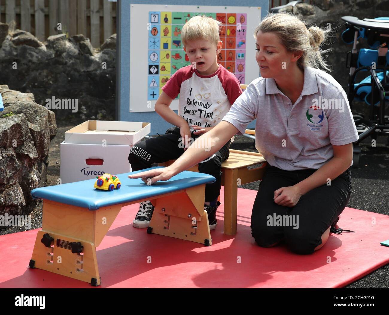 Embargoed to 0001 Monday June 22 Oliver Cunningham with Specialist Physiotherapist Leah Honohan use the weighing scales during a shared theraplay session in the outside therapy area at the Craighalbert Centre. These sessions are taking place to deliver blended learning to children who are shielding. Coronavirus adaptations have been installed at the Scottish Centre for Children with Motor Impairments, Craighalbert Centre, Cumbernauld, as Scotland continues gradually lifting coronavirus lockdown measures. Stock Photo
