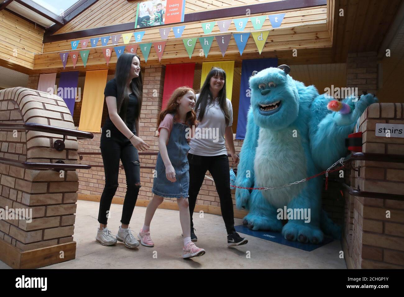 Embargoed to 0001 Monday June 22 Practioner Kimberley O'Meara with her children Hailey and Millie as they walk past Sully, the centre mascot, at the Craighalbert Centre. Coronavirus adaptations have been installed at the Scottish Centre for Children with Motor Impairments, Craighalbert Centre, Cumbernauld, as Scotland continues gradually lifting coronavirus lockdown measures. Stock Photo