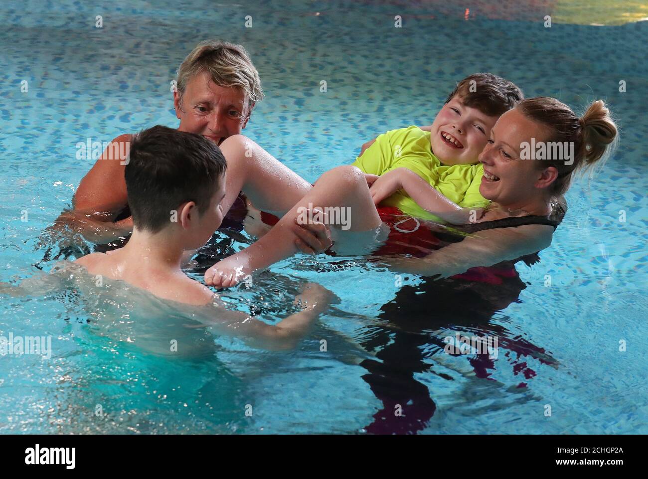 Embargoed to 0001 Monday June 22 Early Years Practitoner Carole King (left) alongside Nicola Devlin with her sons Sean Kearns and Evan (back to camera) as they take part in Parent-led aquatic therapy in the Hydrotherapy pool at the Craighalbert Centre. Coronavirus adaptations have been installed at the Scottish Centre for Children with Motor Impairments, Craighalbert Centre, Cumbernauld, as Scotland continues gradually lifting coronavirus lockdown measures. Stock Photo