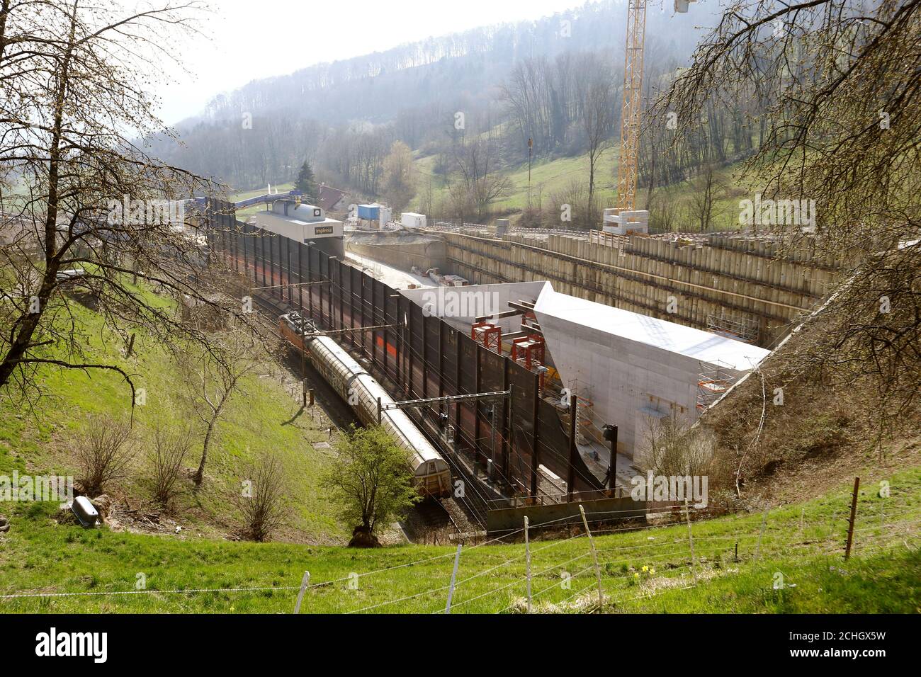 A train leaves the southern entrance of the existing Boezberg tunnel  passing the construction site of the new 2.7 kilometres/1.68 miles long dual -track railway tunnel near Schinznach Dorf, Switzerland April, 1, 2019.