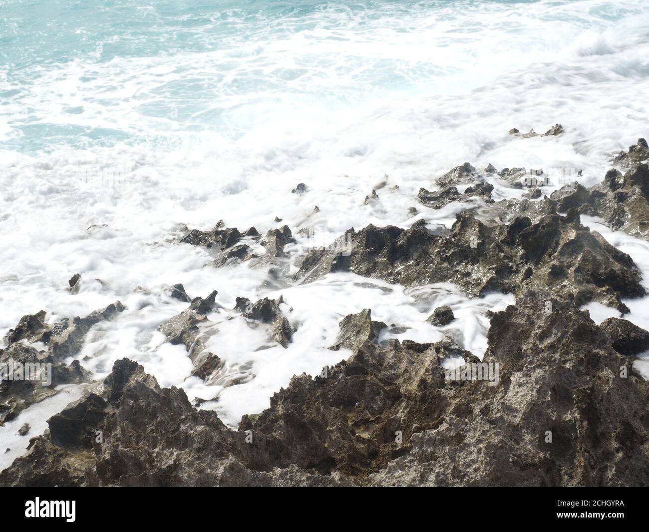 Sharp Rocks Beach Shore High angle shot of a wave crashing into the sharp rocks on the shore ...