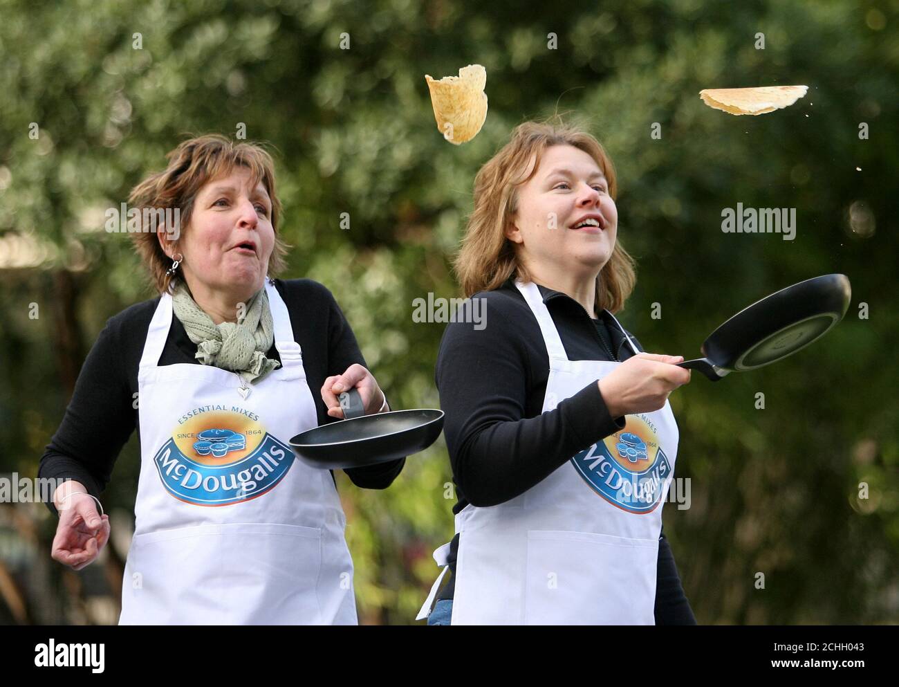Food consultants Helen Woods (left) and Maureen Porteous demonstrating their pancake flipping skills in Soho Square, London ahead of Shrove Tuesday, on February 5. Stock Photo