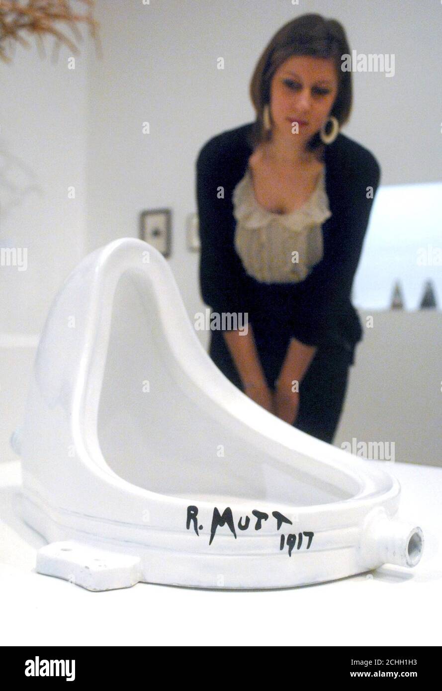 A person looks at Duchamp's Fountain, in the Tate Modern, London, which is part of the gallery's Duchamp, Man Ray and Picaba exhibition which runs from February 21 to May 26, 2008. Stock Photo