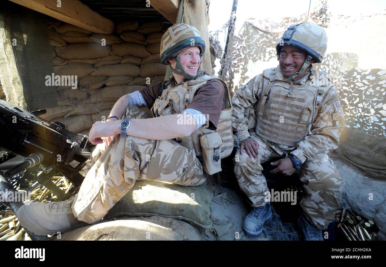 Prince Harry chats to a Gurkha soldier after firing a 50mm machine gun