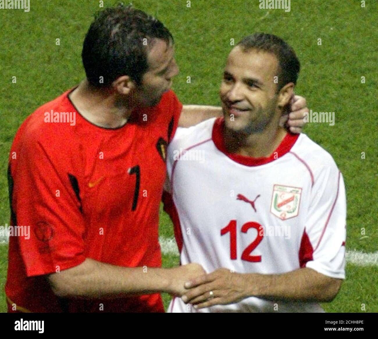 Belgium's captain Marc Wilmots (L) congratulates Tunisia's Raouf Bouzaiene (R) following their World Cup Finals group H soccer match at Oita's Big Eye stadium June 10, 2002. Wilmots and Bouzaiene were the goal scorers in the 1-1 draw. REUTERS/Jim Bourg  JB/GB Stock Photo