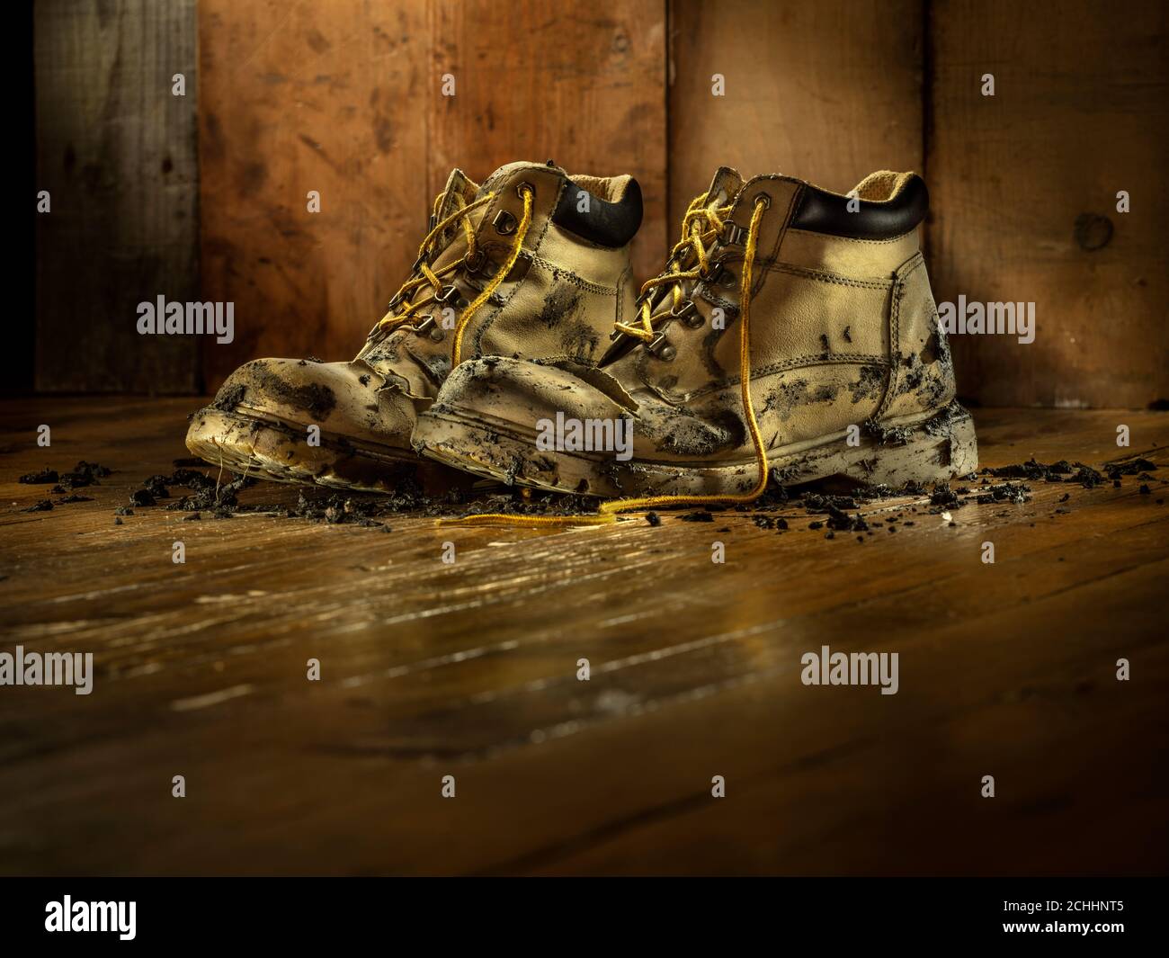 Muddy work boots at the end of a hard day's work Stock Photo