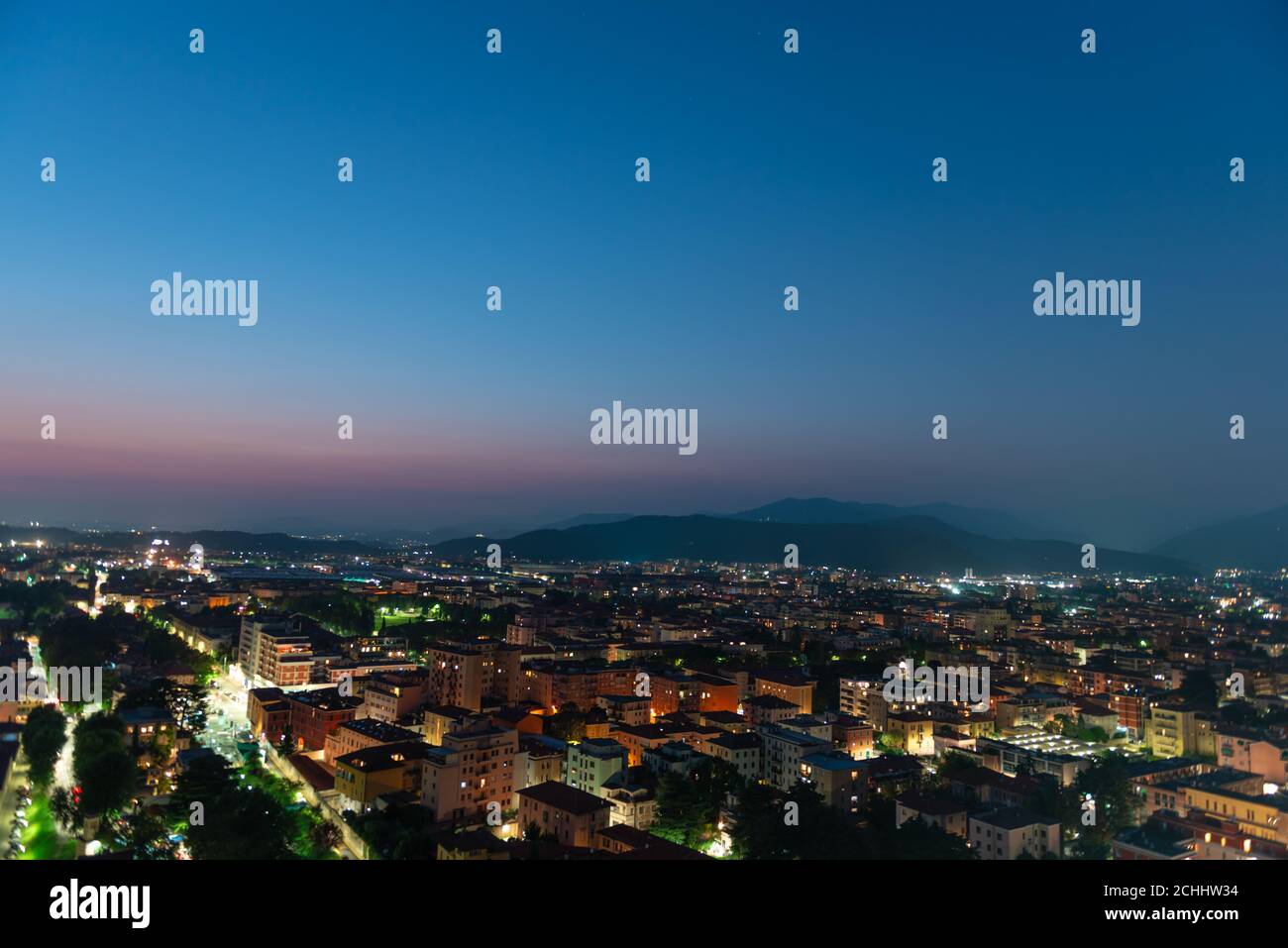 Panorama of the top view of the city in the evening just after sunset. Brescia seen from the castle at night timelapse. Stock Photo