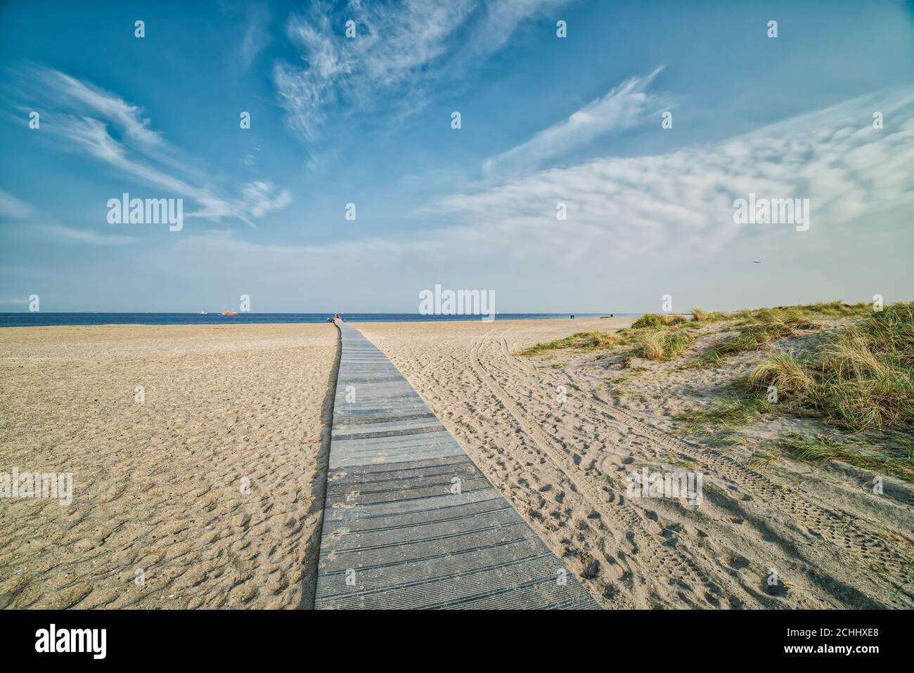 Romantic wooden trail or boardwalk on a beach leads to a calm Baltic Sea conveying realisation and relax concepts. Path to success illustration Stock Photo