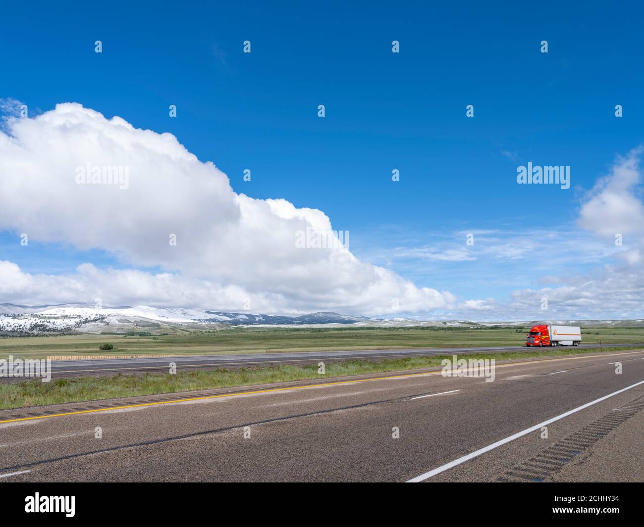 Red truck wide open spaces on highway, Laramie Wyoming USA Stock Photo