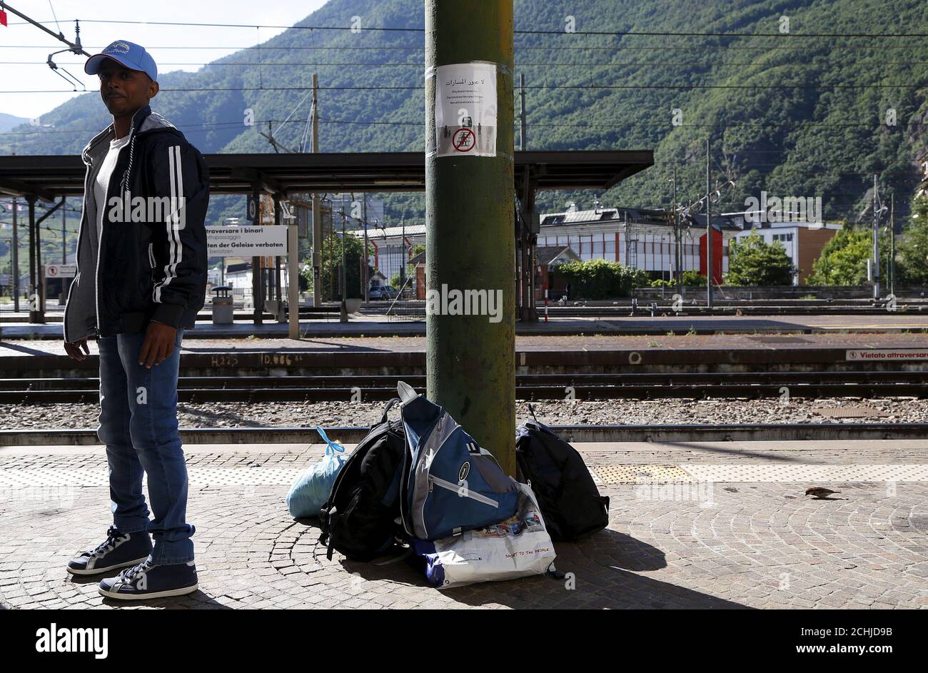 A migrant waits at the Bolzano railway station, northern Italy, May 28, 2015. EU asylum rules, known as the Dublin Regulation, were first drafted in the early 1990s and require people seeking refuge to do so in the European country where they first set foot. Northern European countries defend the policy as a way to prevent multiple applications across the continent. Some are upset with what they see as Italy's lax attitude to registering asylum seekers. Earlier this year, French police stopped about 1,000 migrants near the border and returned them to Italy. Smaller round-ups happen daily in Au Stock Photo