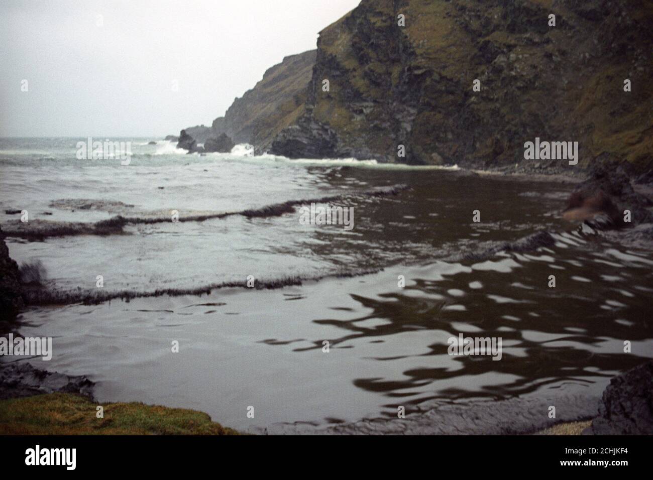 The sea is turned black with oil pollution in the small bay at Garths Wick, near the area where the tanker MV Braer is stuck on the rocks in Shetland. Stock Photo