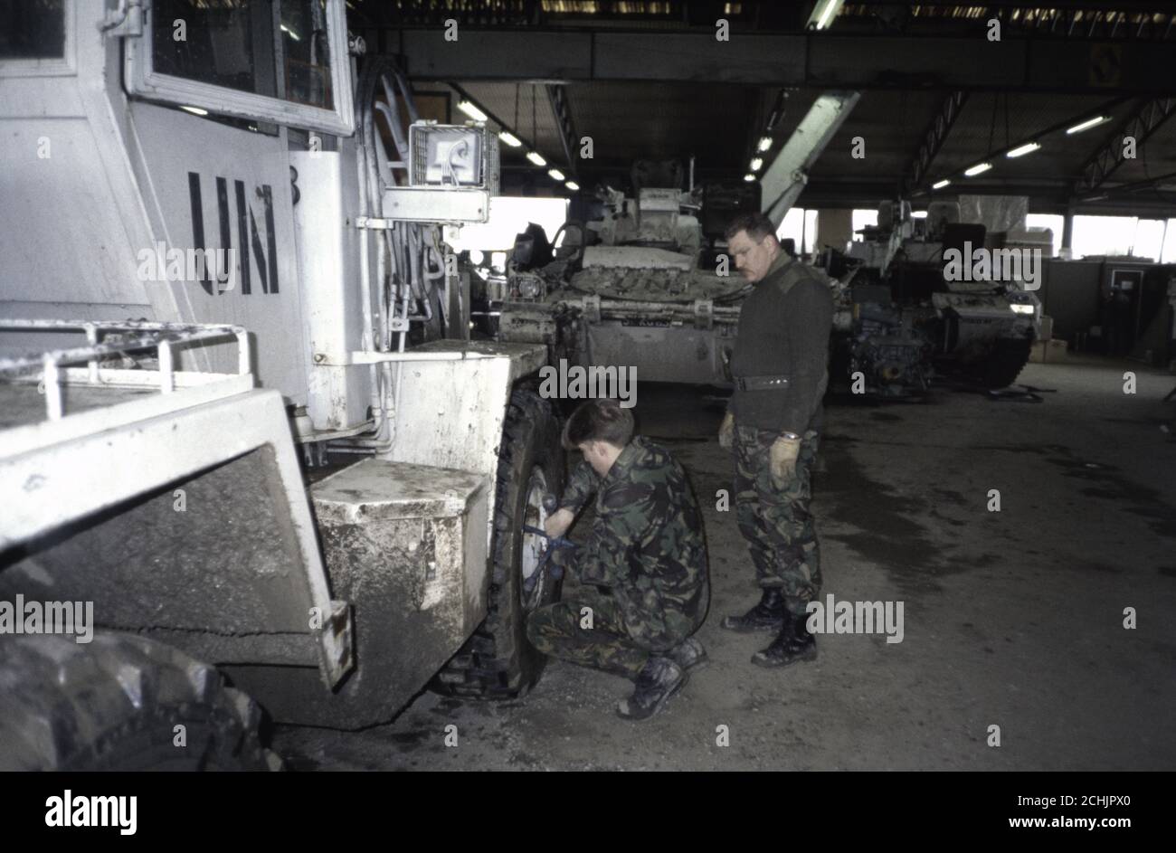 3rd March 1994 During the war in Bosnia: British Army soldiers work on a bulldozer at the REME garage in Vitez. Stock Photo