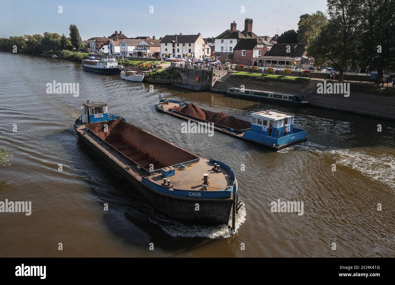 Two barges pass each other on the River Severn as they pass the town of Upton on Severn in Worcestershire. Stock Photo