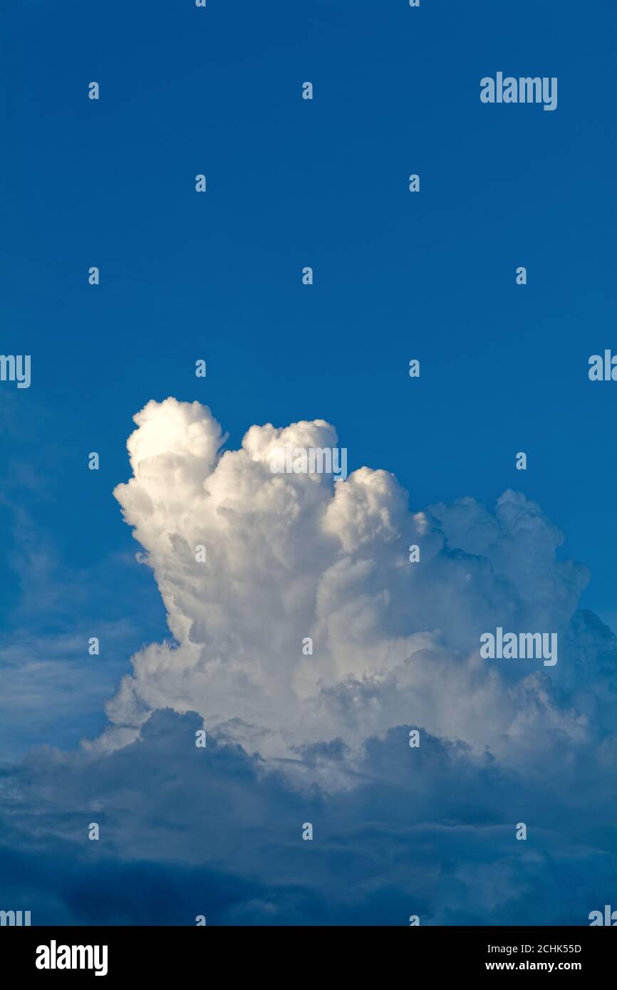 Dark cumulus cloud formation against a very dark blue background Stock Photo