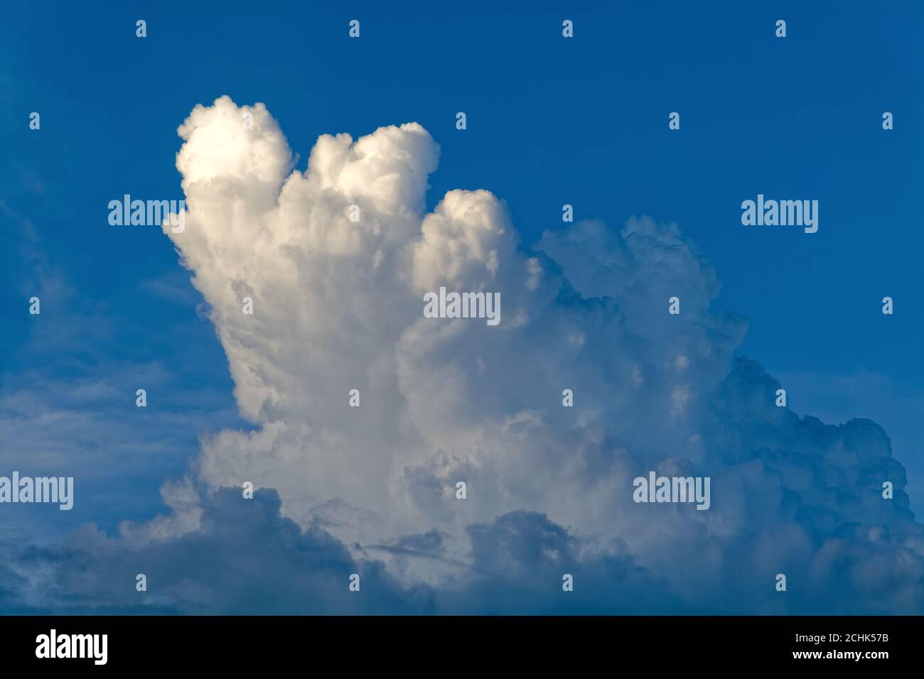 Dark cumulus cloud formation against a very dark blue background Stock Photo