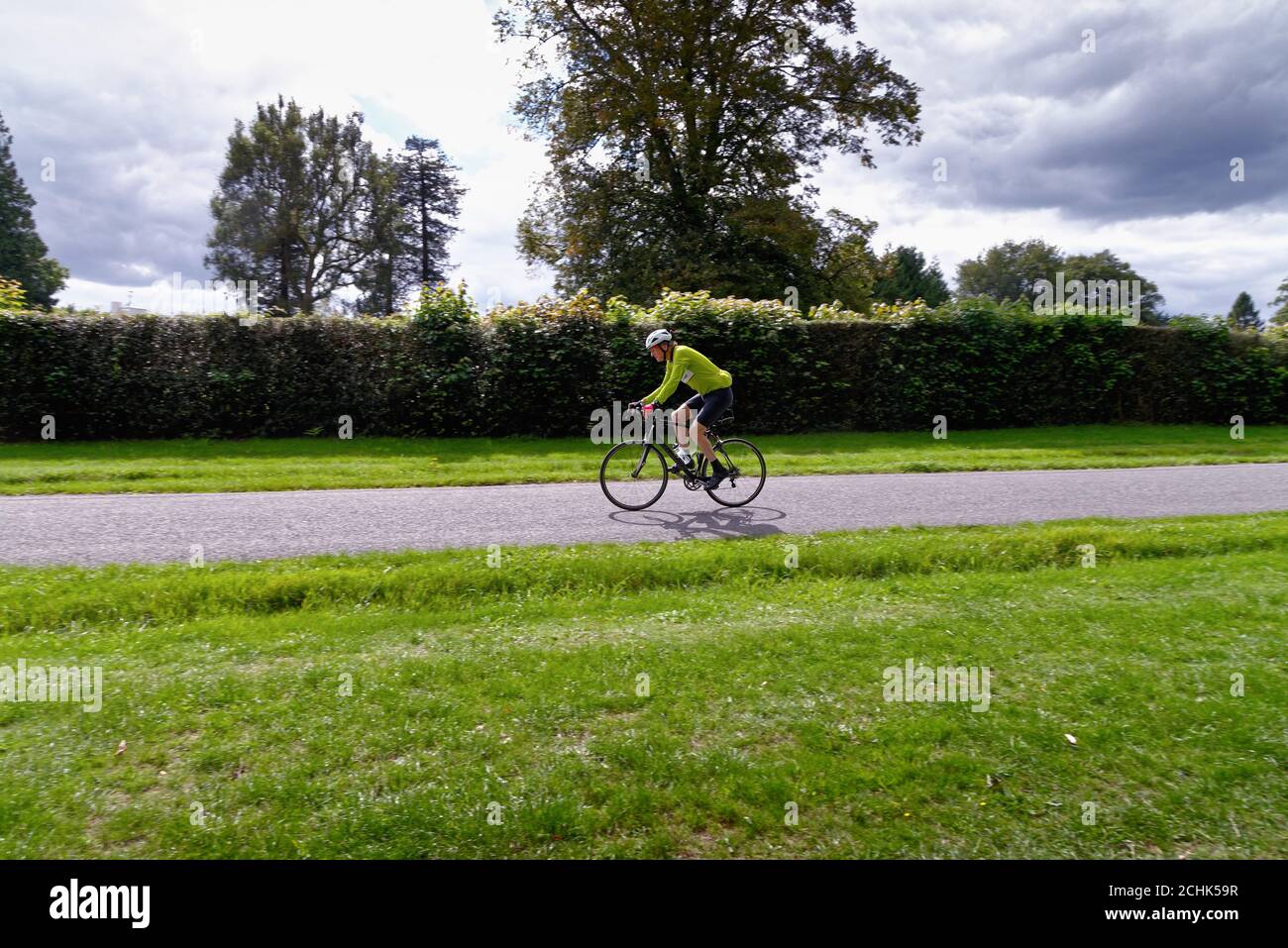 A middle aged male cyclist riding on a country road in the Surrey Hills near Dorking Surrey England UK Stock Photo