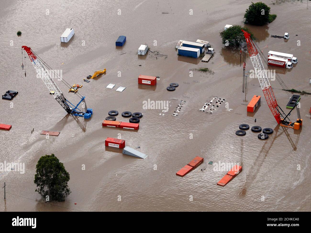 Cranes submerged under flood waters in an industrial area of ...