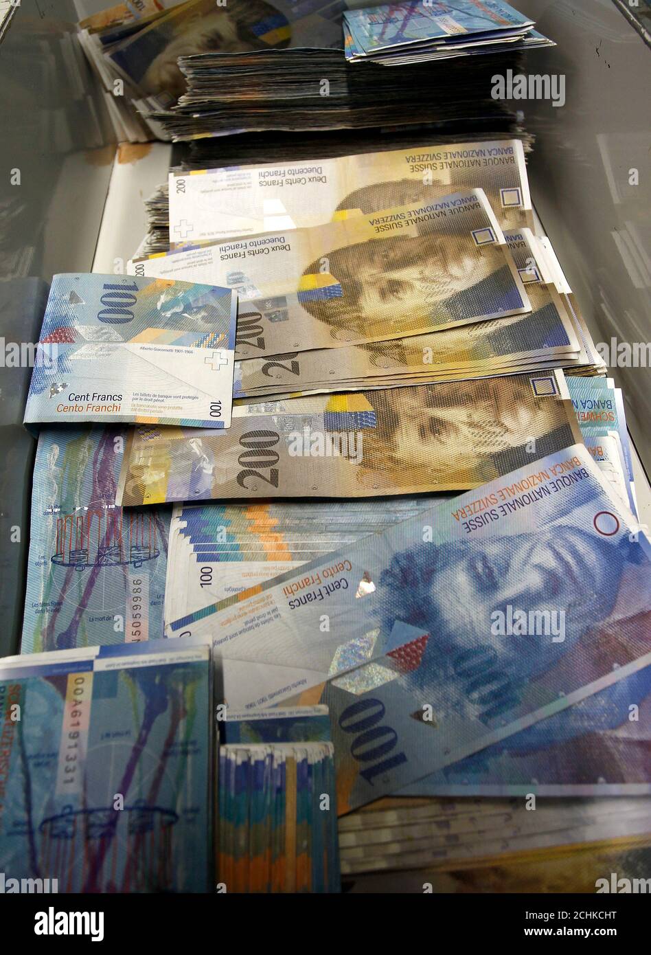 Swiss franc banknotes of several values lie in a box before sorted in a  money counter in a bank in Zurich August 16, 2011. Switzerland's central  bank may not cave in to