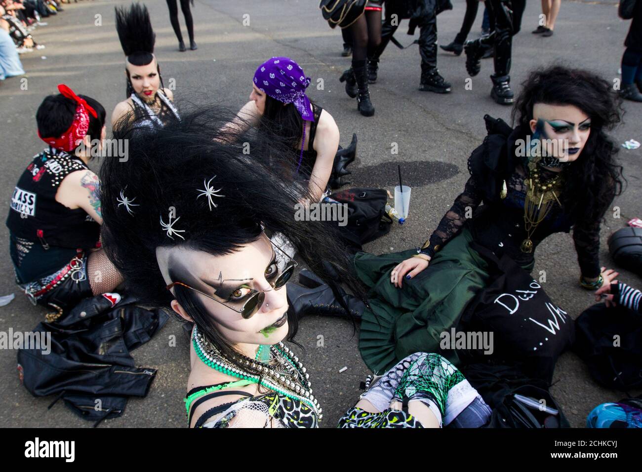 Revellers in their subculture attire sit on the pavement outside of a venue of the Wave and Goth festival in Leipzig May 26, 2012. The annual festival, known in Germany as Wave-Gotik Treffen, features over 150 bands and artist in venues all over the city playing Gothic rock and other styles of the dark wave music subculture. The event that counts as one of the biggest of its kind attracts a regular audience of up to 20,000 the organisers said.  REUTERS/Thomas Peter  (GERMANY - Tags: ENTERTAINMENT TPX IMAGES OF THE DAY) Stock Photo