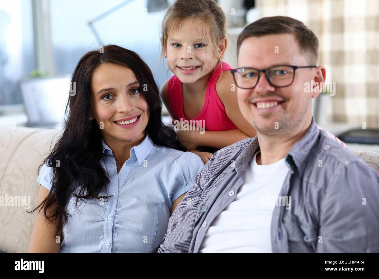 Cheerful parents with daughter at home Stock Photo