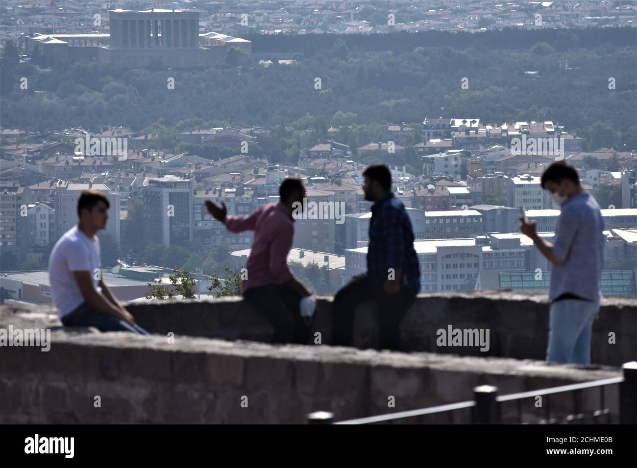 Ankara, Turkey. 14th Sep, 2020. Visitors enjoy a view of the urban skyline at Ankara Castle, a famous tourist attraction in the Turkish capital, as Anitkabir, the mausoleum of modern Turkey's founder Mustafa Kemal Ataturk, is seen in the background during the last days of summer tourism. Despite the high risk of coronavirus (COVID-19), tourists continue to visit popular locations in the city. Credit: Altan Gocher/ZUMA Wire/Alamy Live News Stock Photo