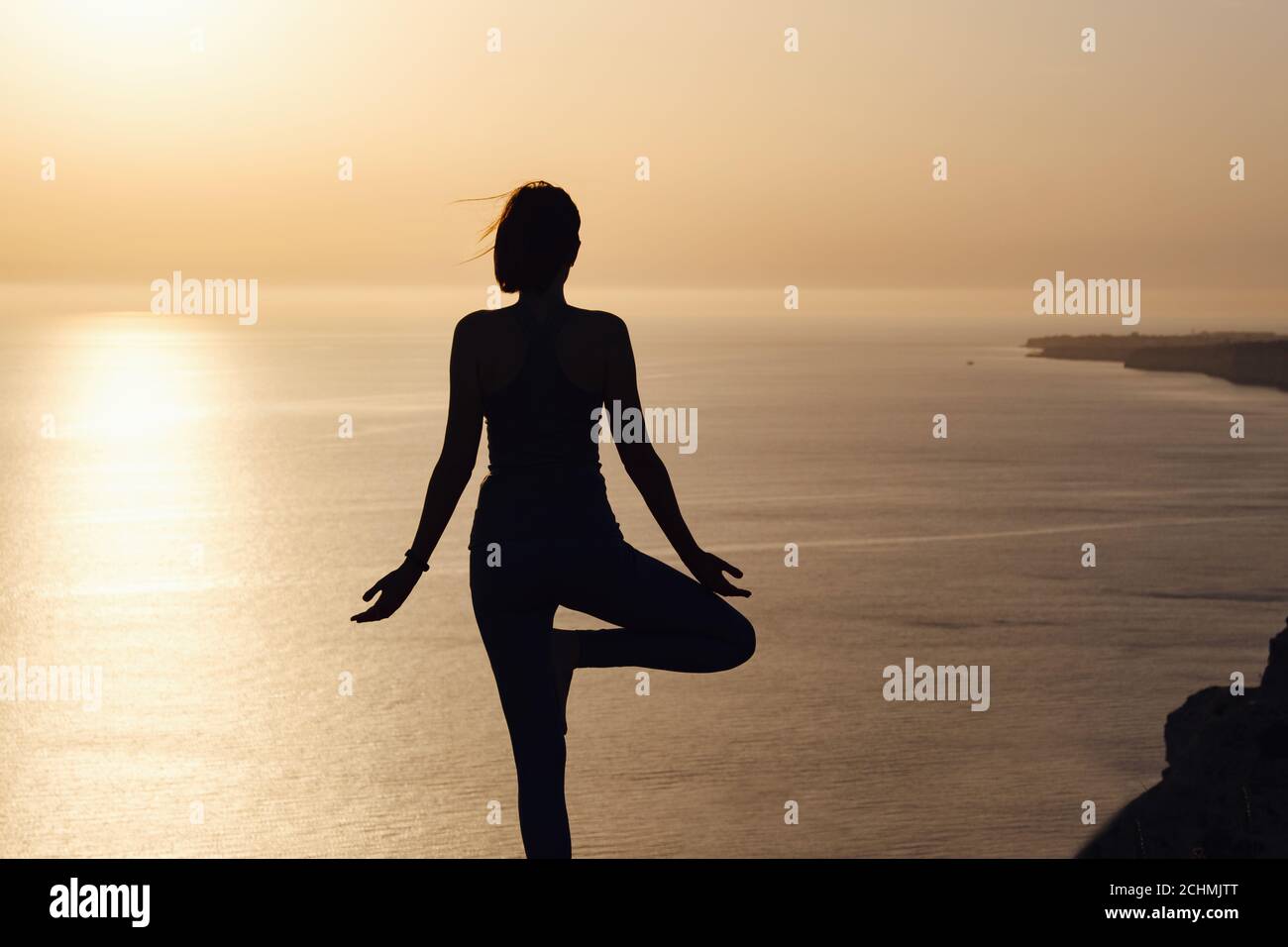 The woman with yoga posture on the mountain at sunset Silhouette of ...