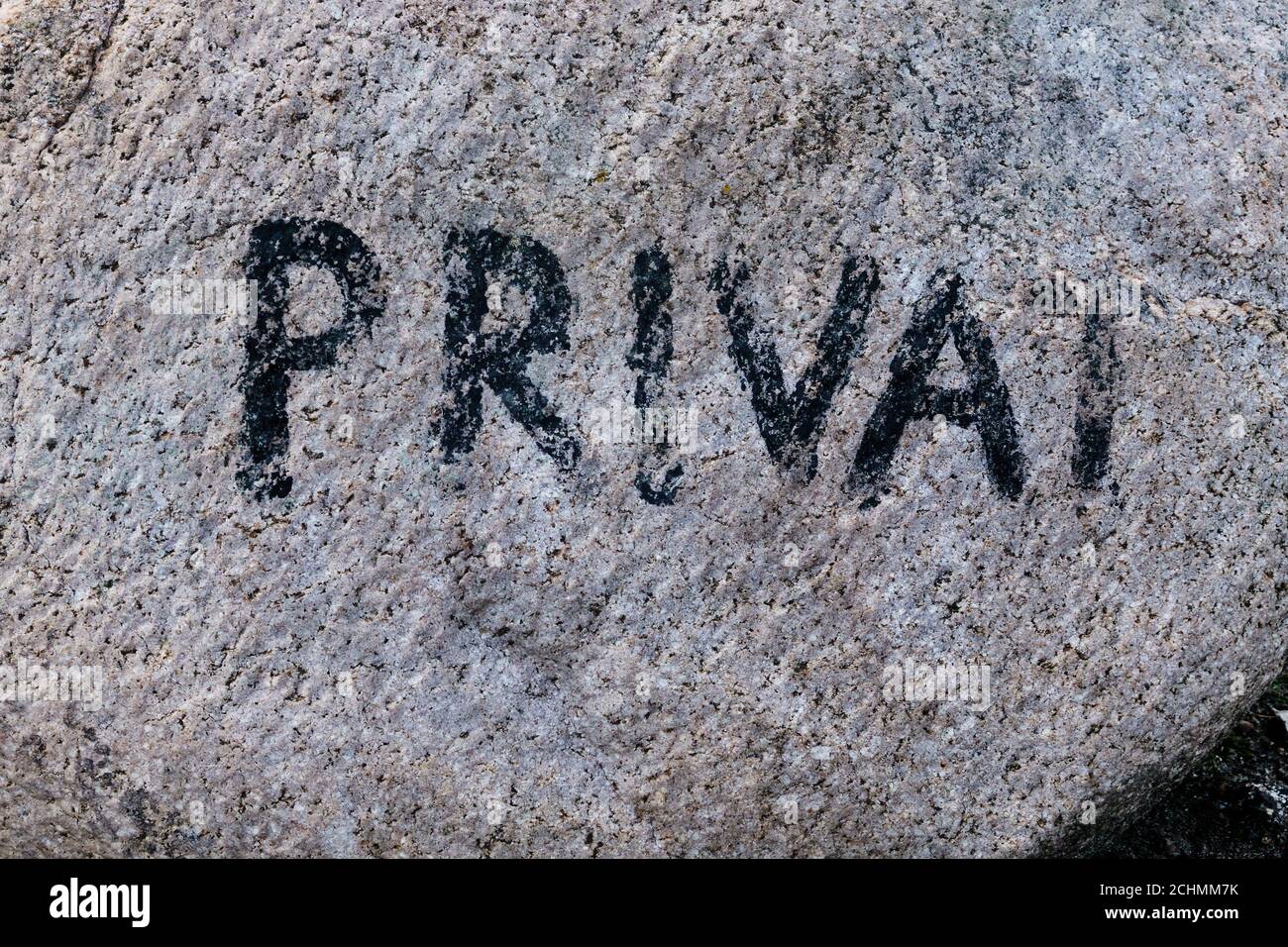 Bright granite erratic block with the faded inscription private to mark the end of the public area Stock Photo