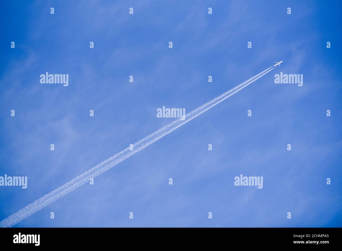 Plane flies in the sky leaving behind a strip Stock Photo Alamy