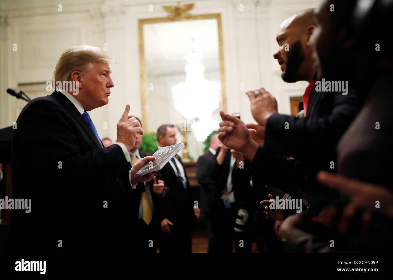 U.S. President Donald Trump speaks with author David J Harris Jr as he holds Harris's book 'Why I Couldn't Stay Silent' after the president delivered remarks at the '2018 Young Black Leadership Summit' in the East Room of the White House in Washington, U.S., October 26, 2018. REUTERS/Carlos Barria Stock Photo