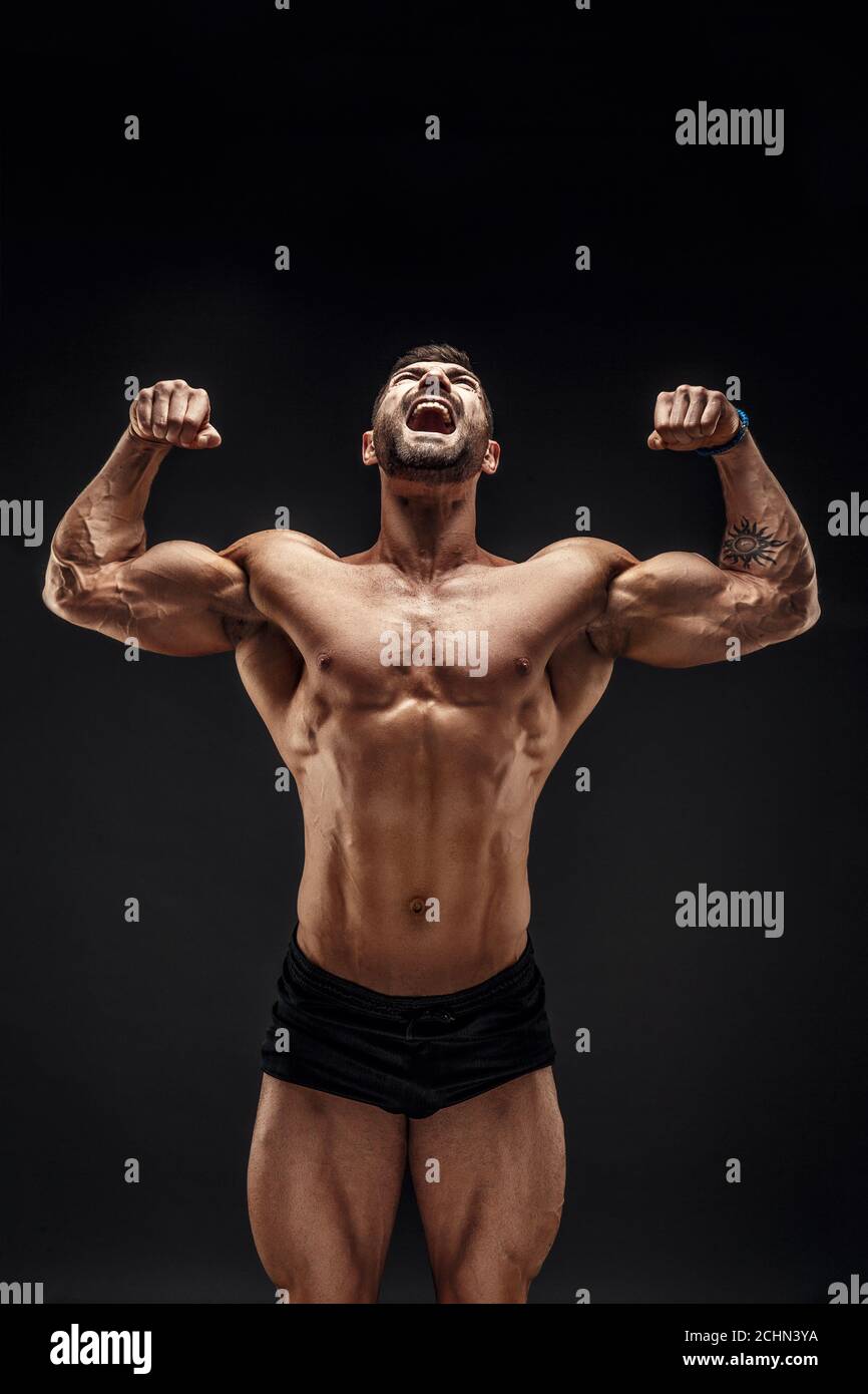 Handsome muscular shirtless man screaming and looking up isolated on black  Stock Photo - Alamy