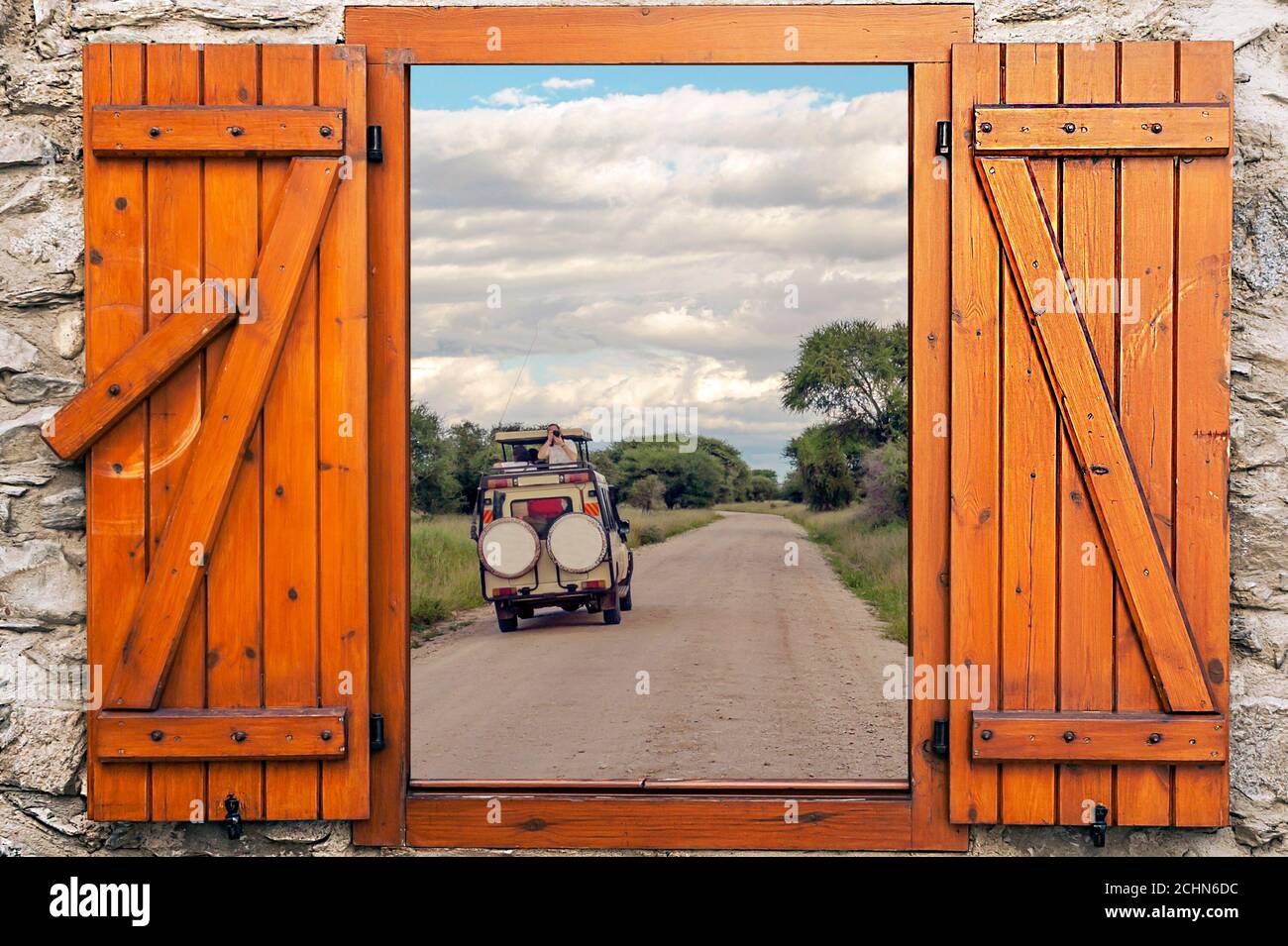 Safary cars in Kenya on a cloudy day.  Its a point of view from wood window. Stock Photo