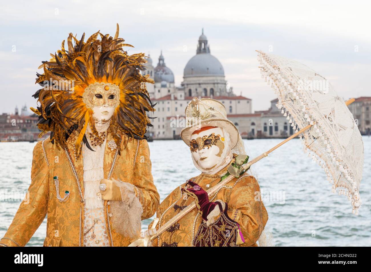 Venice, Veneto, italy  - Couple  in costume at the Venice Carnival  posing with backdrop of Basilica de Santa Maria della Salute and lagoon Stock Photo