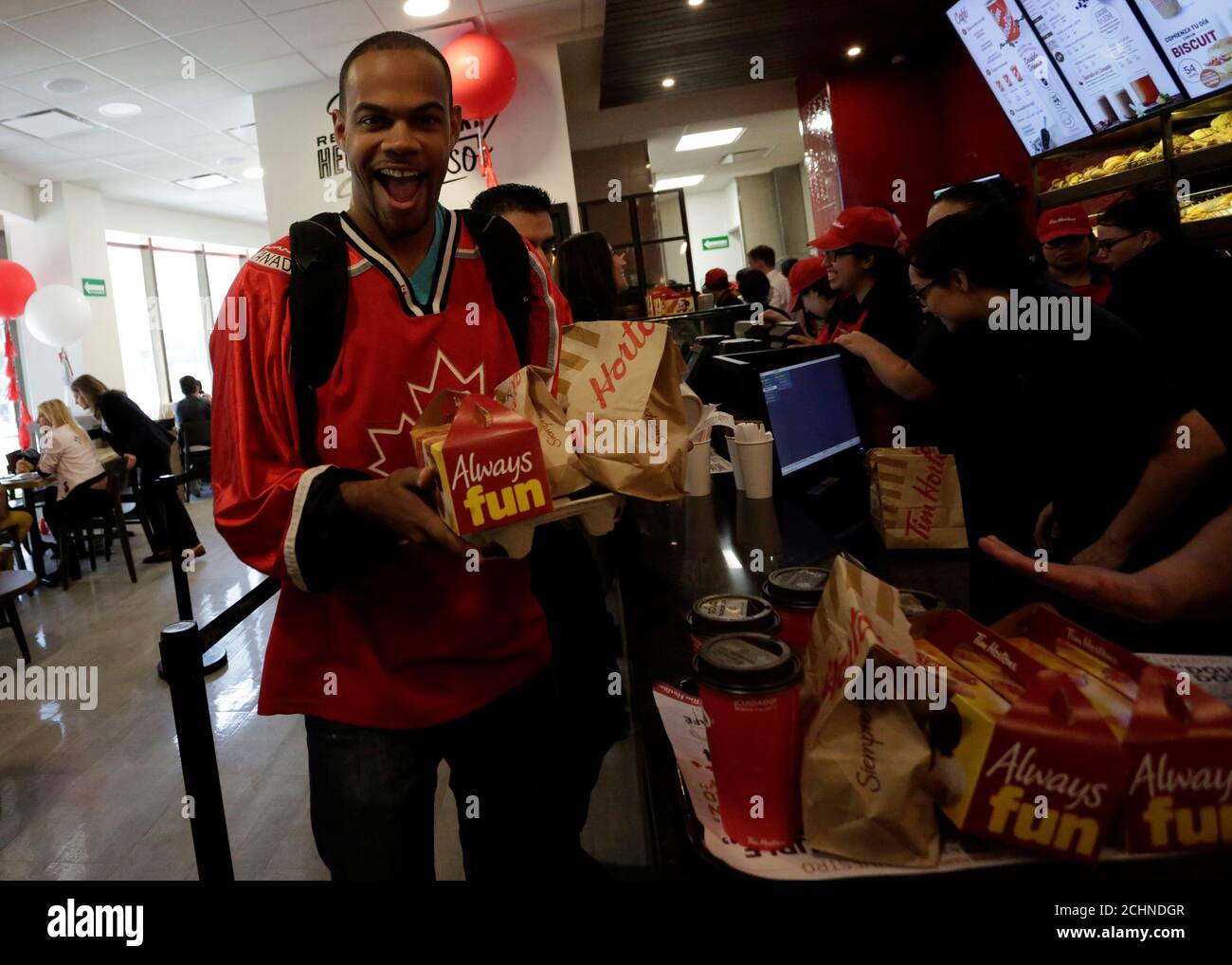 A Canadian citizen reacts to the camera after purchasing coffee, timbits and a sandwich during the opening of the Tim Hortons coffee shop in San Pedro Garza Garcia, in Monterrey, Mexico, October 27, 2017. REUTERS/Daniel Becerril Stock Photo