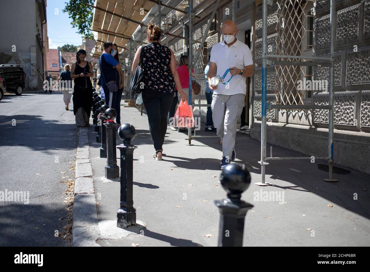 Belgrade, Serbia, Sep 4, 2020: People walking down the street under scaffolding mounted on the front wall of Zemun municipality building Stock Photo