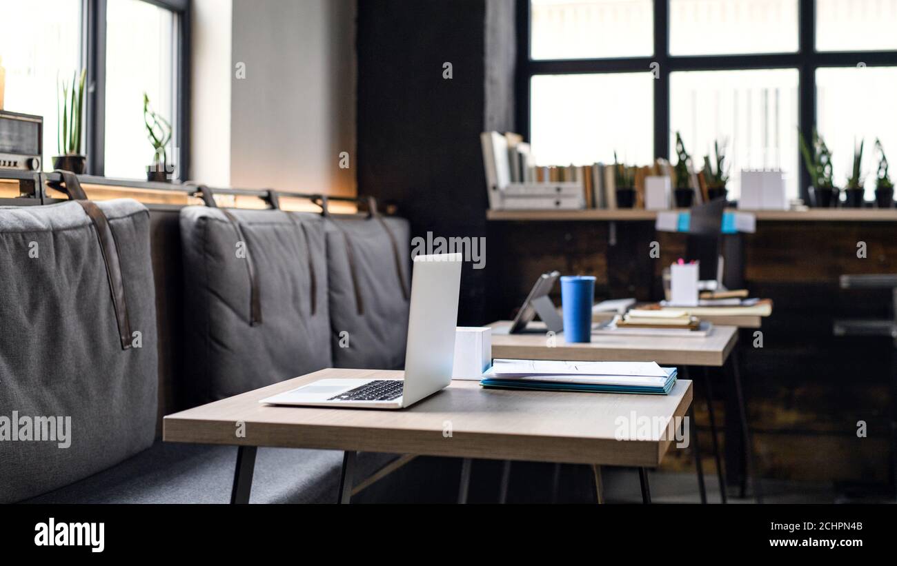 Laptops on desks in empty modern office. Stock Photo