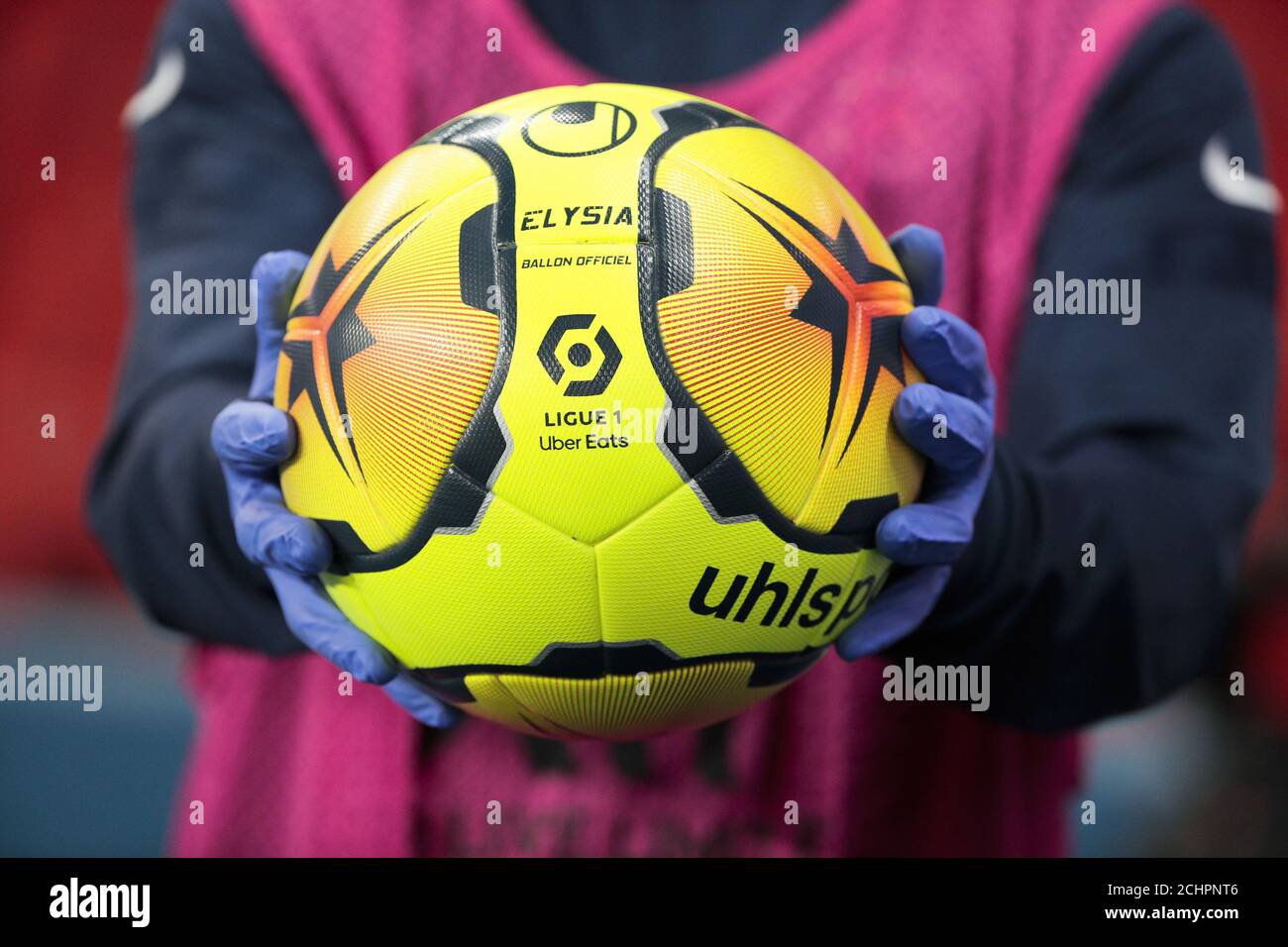 Illustration of the official ball Ligue 1 Uber Eats Elysia by Uhlsport saison 2020 - 2021 in hand of line out assistant weared with surgical gloves ag Stock Photo