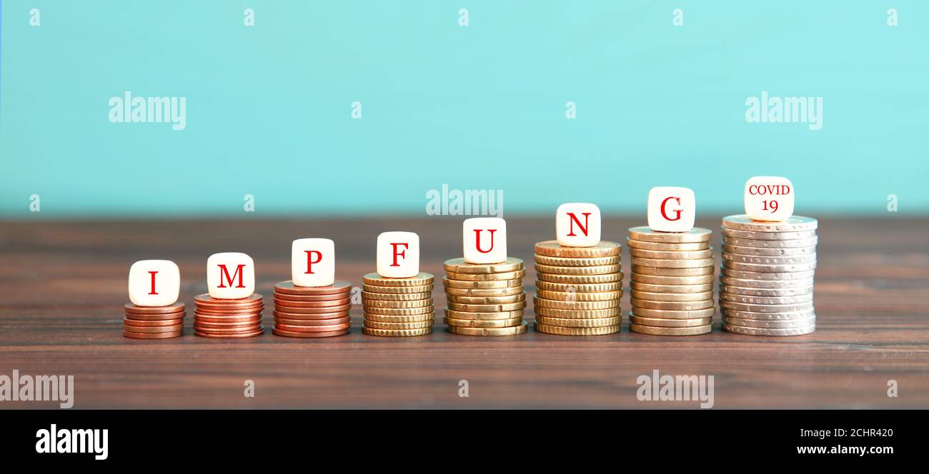 expenses due to the corona pandemic. dice form german expression Impfung COVID-19 (Vaccination COVID-19) increasing high stack of coins . rising costs Stock Photo