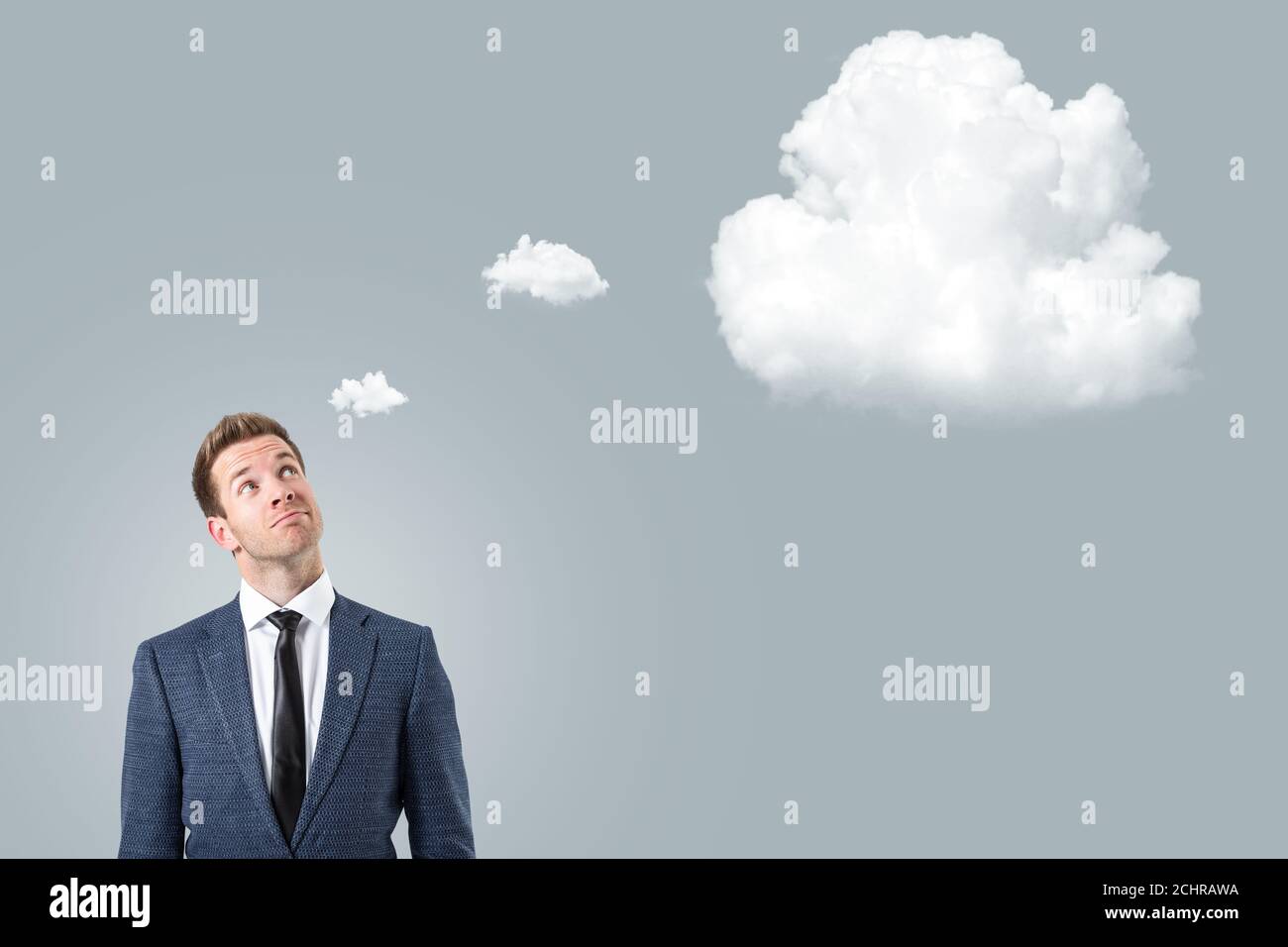 Businessman looking up towards a thought bubble Stock Photo