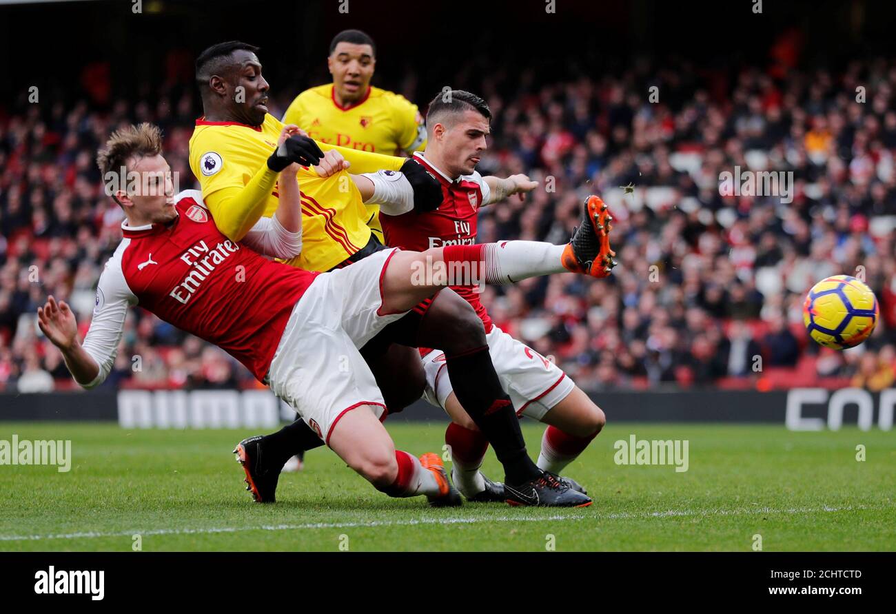 Soccer Football - Premier League - Arsenal vs Watford - Emirates Stadium, London, Britain - March 11, 2018   Arsenal's Rob Holding and Granit Xhaka in action with Watford's Stefano Okaka      REUTERS/Eddie Keogh    EDITORIAL USE ONLY. No use with unauthorized audio, video, data, fixture lists, club/league logos or 'live' services. Online in-match use limited to 75 images, no video emulation. No use in betting, games or single club/league/player publications.  Please contact your account representative for further details. Stock Photo