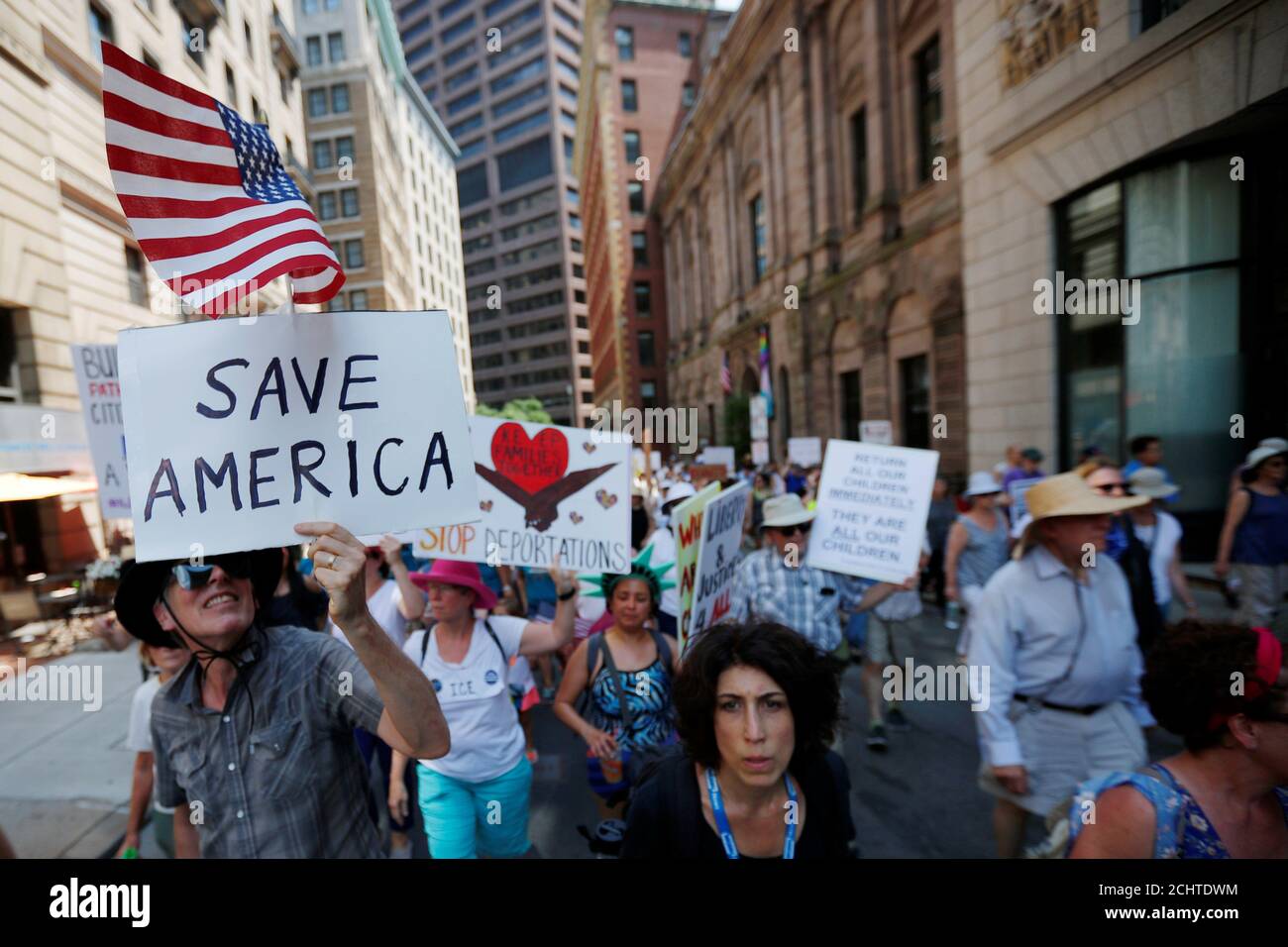 Demonstrators carrying signs, including one reading 'Save America', march during the 'Families Belong Together' rally in Boston, Massachusetts, U.S., June 30, 2018.   REUTERS/Brian Snyder Stock Photo