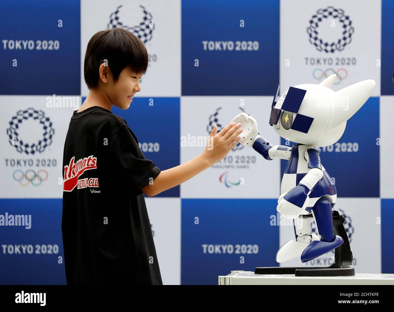 Tokyo 2020 mascot robot Miraitowa, which will be used to support the Tokyo  2020 Olympic and Paralympic Games, exchanges high-five with a boy during  the robot unveiling event to celebrate the first